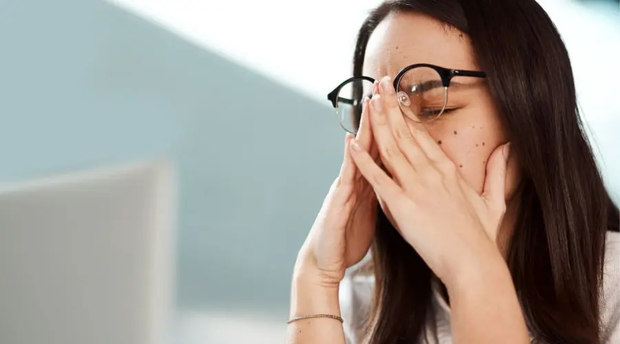 A woman showing stress at her desk shows the concept of relapse triggers