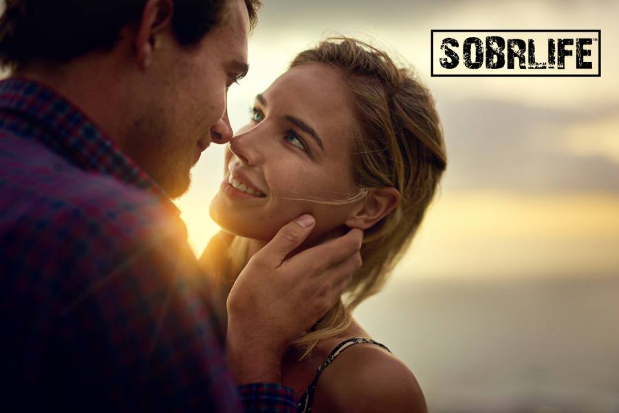 A man and a woman are about to kiss on the beach to show the concept of sex in recovery from addiction